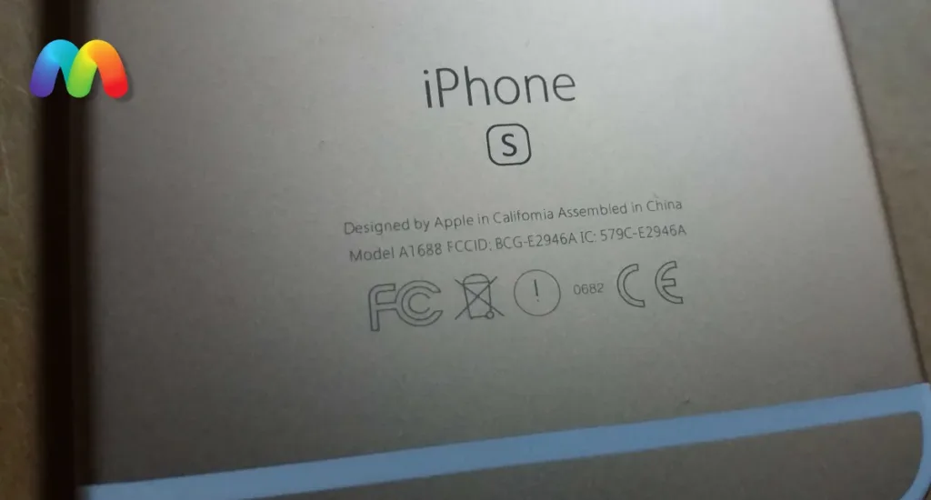 Крупный план задней панели золотистого iPhone с выгравированным номером модели A1688 и знаками соответствия.