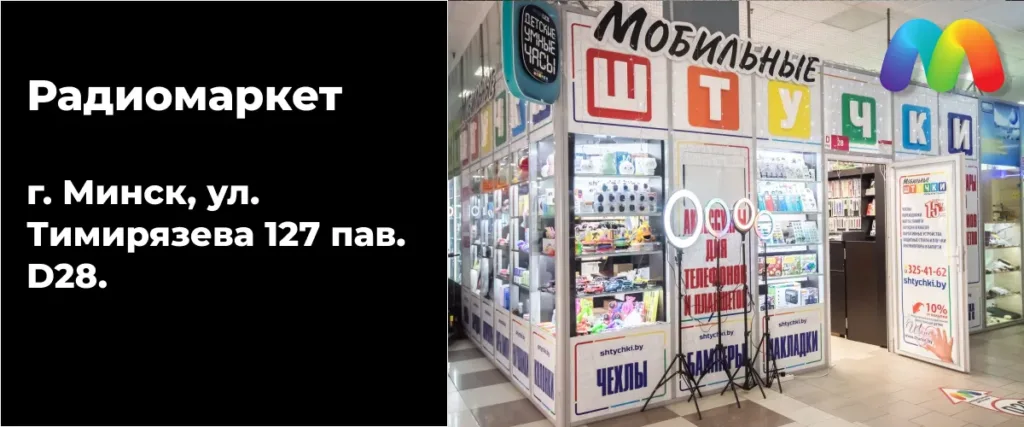 Фасад магазина "Мобильные Штучки" в Радиомаркете. Вход в магазин оформлен вывеской с названием и логотипом. Внутри и снаружи магазина на стендах представлены аксессуары, такие как чехлы и гидрогелевые пленки.