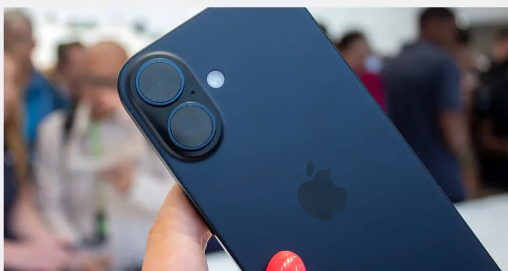 Человек держит темно-синий iPhone (возможно, концепт iPhone 16) с двумя камерами, расположенными вертикально. Виден логотип Apple.