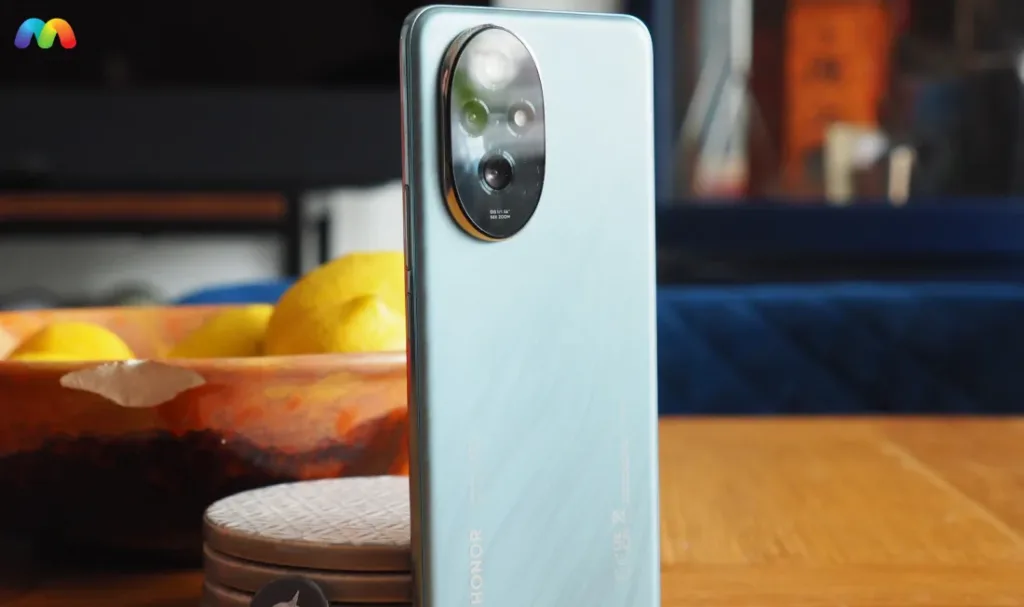 Спинка смартфона Honor бирюзового цвета с матовой отделкой и овальным модулем тройной камеры.