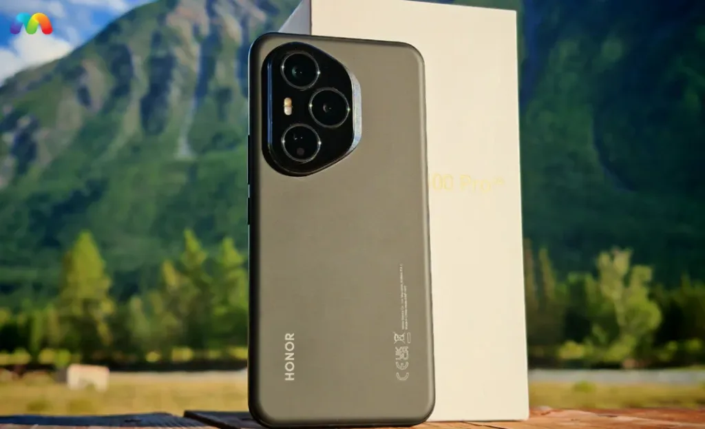 Смартфон Honor 400 серого цвета сзади, на фоне гор и коробки.