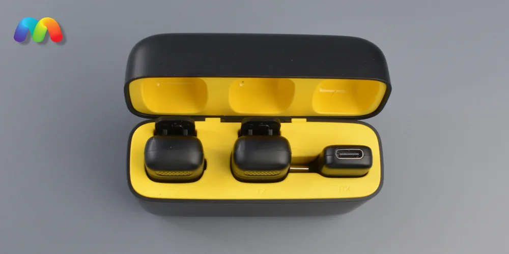 Черный зарядный чехол открыт, демонстрируя два черных передатчика (TX) и один приемник (RX) с USB-C/Lightning коннектором внутри ярко-желтых ячеек.