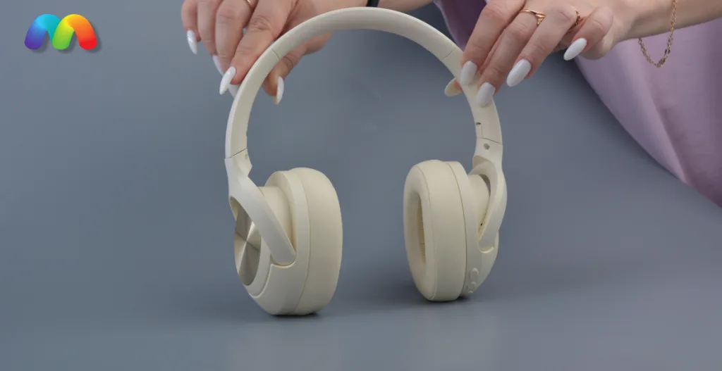 Беспроводные наушники Hoco W54 с режимом ANC 4 Руки держат кремовые беспроводные накладные наушники.