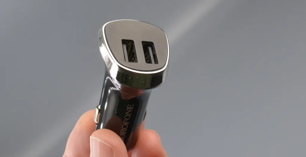 Рука держит зарядное устройство Borofone BZ15 крупным планом с акцентом на два USB-порта.