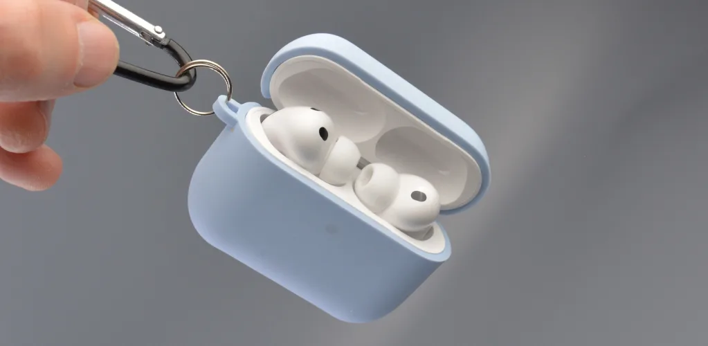 Светло-голубой чехол для наушников AirPods, подвешенный на металлическое кольцо.